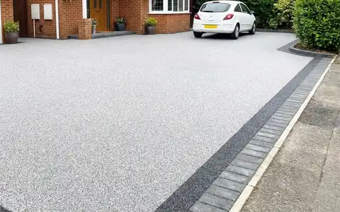 Light grey resin bound driveway with a charcoal border