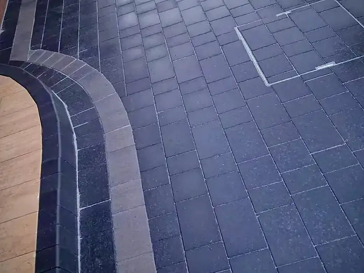 Close-up of charcoal block paving with a curved contrasting border, Stafford